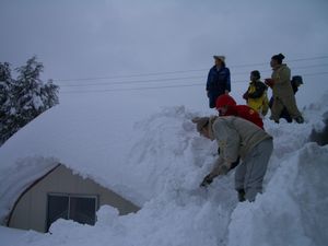 住民の方とお話しているのは屋根の上・・・ほとんどの家屋が全壊だそうだが、すべて雪の中で実感できません。